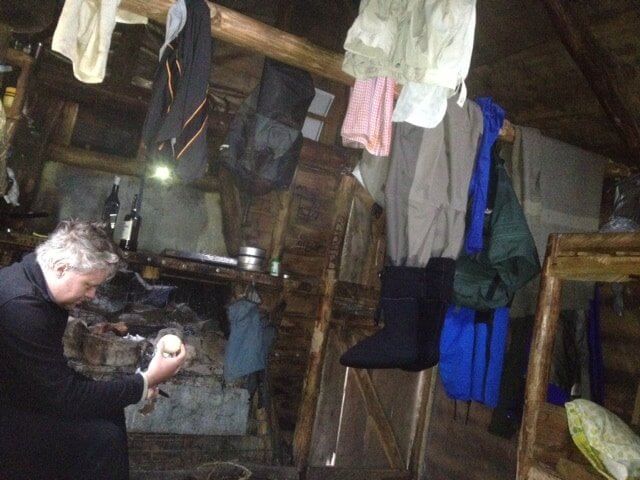 Matt cooking up a treat in a classic Tassie Hut