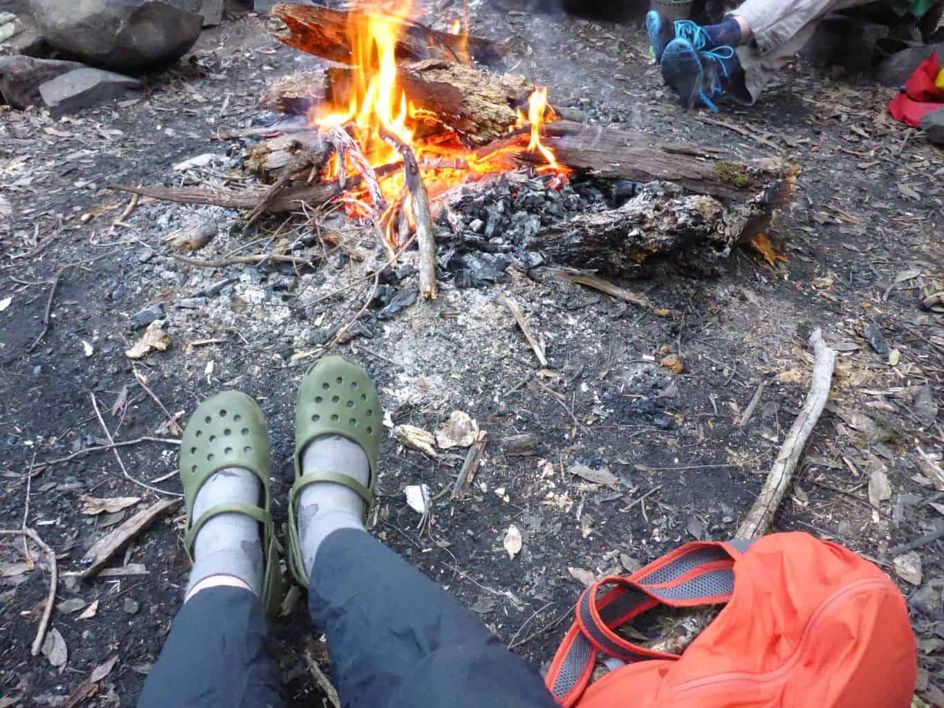 Relaxing by the fire, water and food in my orange foldable backpack.
