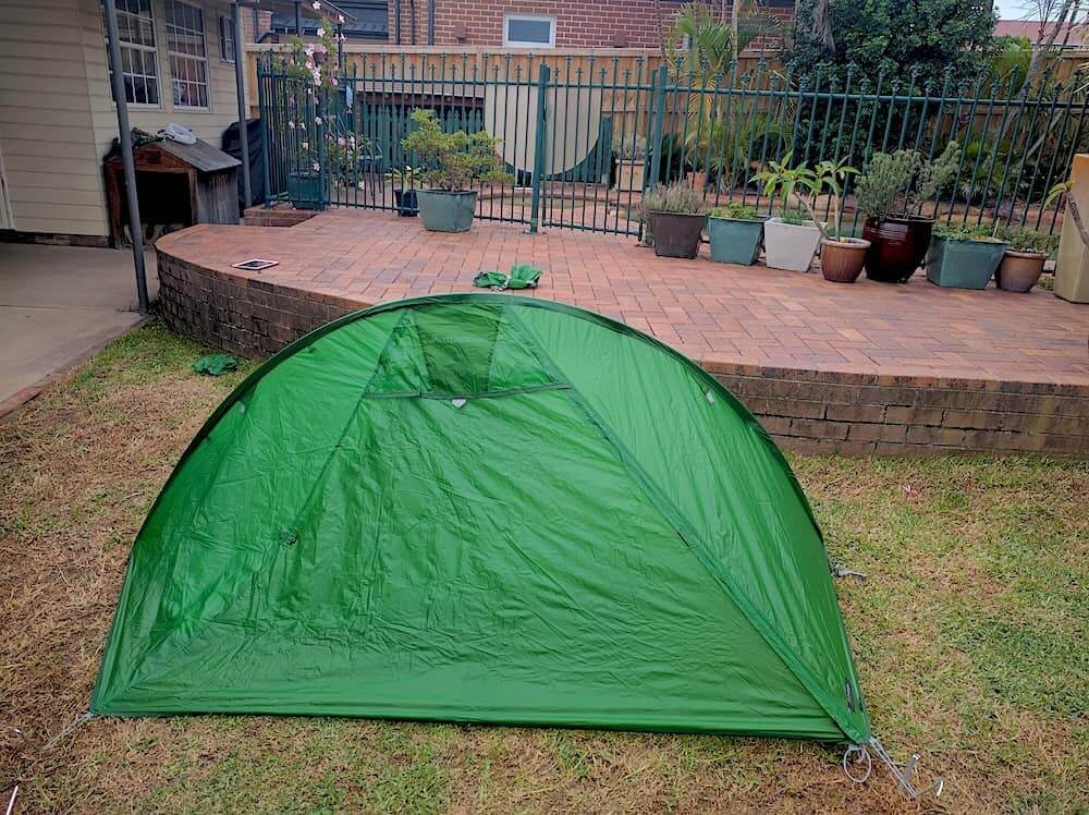 Green hiking tent in backyard