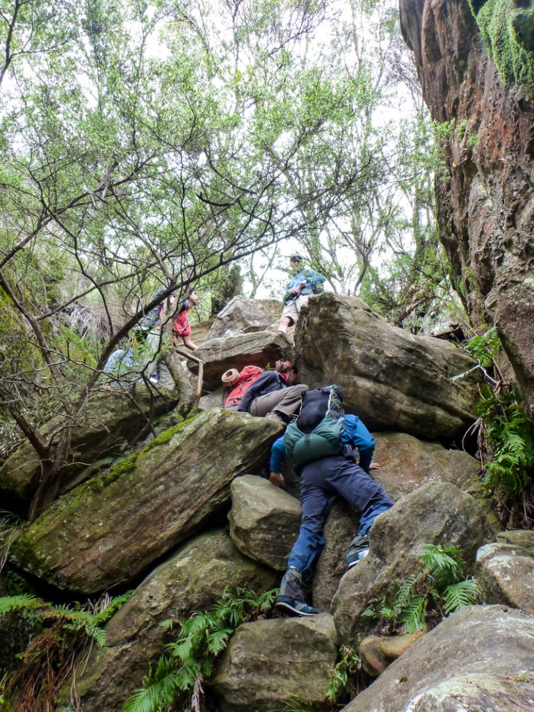 hikers scramble down gully