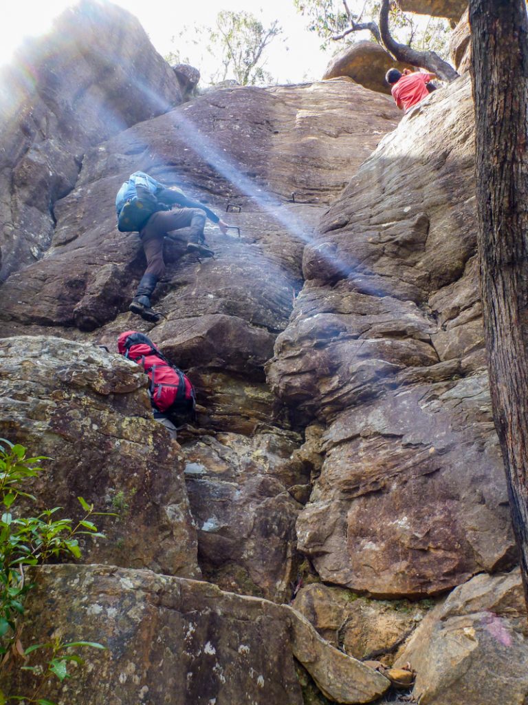 hikers climb spikes and rungs