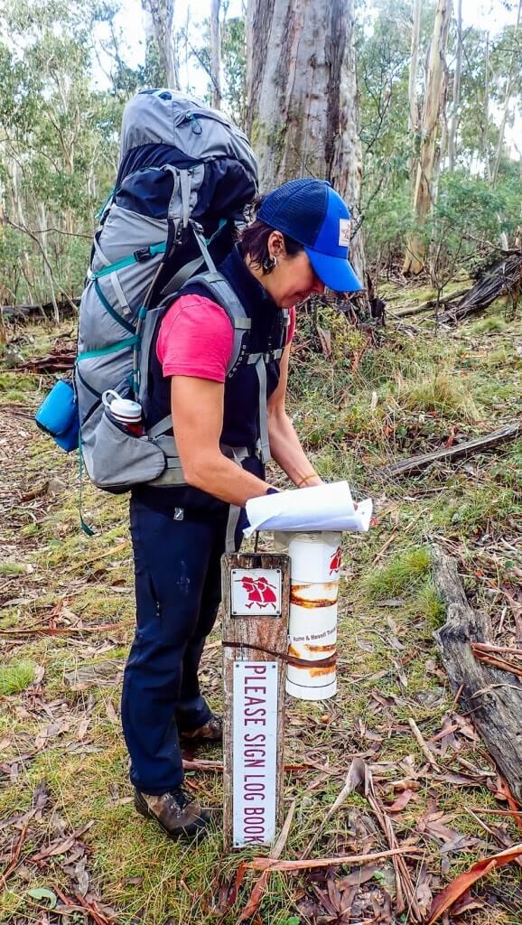 hiker fills out log book on Hume and Hovell Track