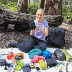 woman packs backpack for hiking