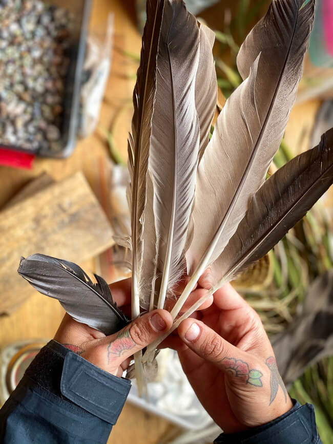 woman's hands holding feathers