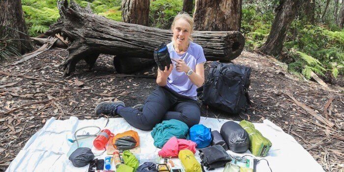 woman packs backpack for hiking